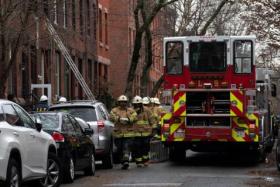 Firefighters at the scene of a blaze that overwhelmed a crowded Philadelphia rowhouse on Jan 6, 2022.