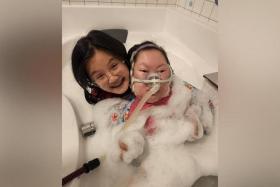 Amanda Ng has been caring for her sister Amelia, who has a rare genetic disorder that has since robbed her of the ability to talk, chew or urinate.