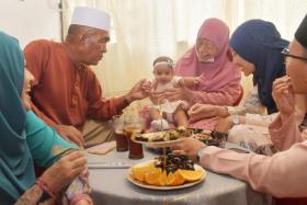 Five-month-old Zea Fathia Muhammad Hasnul (centre) celebrates Hari Raya with her relatives on May 3, 2022.