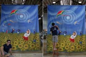 Local artist Yip Yew Chong working on a painting of children flying kites in a sunflower field, on March 19, 2022.
