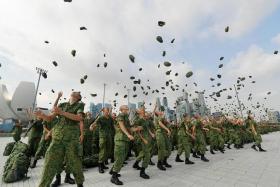 Recruits toss their jockey caps at the NS55 Integrated Parade at The Float @ Marina Bay on Nov 26, 2022.