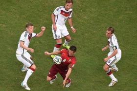 CONTROL: Germany&#039;s Toni Kroos, Mario Goetze and Philipp Lahm (in white, clockwise) give Portugal&#039;s Joao Moutinho little space in their 4-0 win.