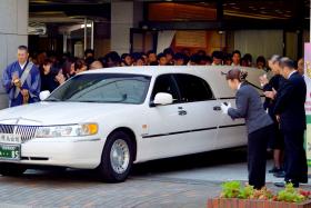 A hearse carrying the coffin of Japanese schoolgirl Aiwa Matsuo, who was murdered by a classmate, leaving the funeral hall in Sasebo, western Japan, on July 29. 