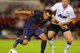 Barcelona&#039;s Xavi Hernandez tussles with Manchester United midfielder Paul Scholes during a pre-season friendly in 2012. 