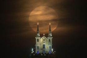 The full moon descends behind the Nossa Senhora da Penha Church in Rio de Janeiro, Brazil, on August 10, 2014. In this time of the year the orb is at the closest point to the earth.
