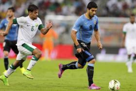 Luis Suarez (right) runs with the ball as Saudi Arabia&#039;s Mustafa Al Bassas chases during their friendly football match at King Abdullah stadium in Jeddah October 10, 2014.