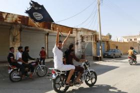 File photo of a supporter of the Islamic State of Iraq and Syria (ISIS) waving their flag.
