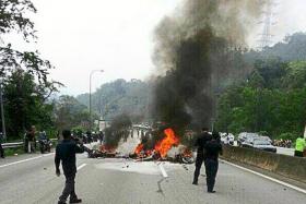The burning wreckage of one of the motorcycles following the accident along the Karak Highway, which links Kuala Lumpur to the east coast of Malaysia.