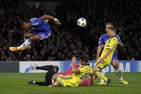 MAKING THE LEAP: Didier Drogba jumping to avoid clashing with Maribor&#039;s Slovenian goalkeeper Jasmin Handanovic (in pink).