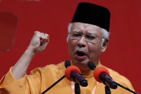 Malaysia&#039;s Prime Minister Najib Razak gestures as he gives the keynote address during the United Malays National Organisation (UMNO) annual assembly at the Putra World Trade Centre in Kuala Lumpur November 27, 2014.