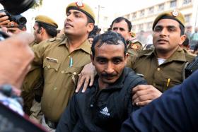 Indian police escorting Uber taxi driver and accused rapist Shiv Kumar Yadav (centre) following his court appearance in New Delhi on Dec 8.
