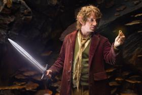 Martin Freeman as Bilbo Baggins in The Hobbit holding Sting, an elven sword that glows blue in the presence of orcs.