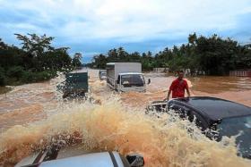  Motorists passing through the flooded Temerloh-Jerantut road near Kampung Tebing Tinggi in Kuala Krau, Pahang.