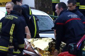 Rescue service workers and firefighters evacuate an injured person on a stretcher near the site of a shooting on Thursday evening (local time) in Montrouge, south of Paris.