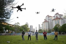 FLY AWAY: (From left) PhD researcher Ervine Lin, lawyer Roe Yun Song, tutor Gan Weili, medical technologist Alvin Wong and IT engineer Aramid Lee flying their drones at Tanjong Rhu.