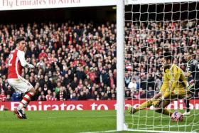 Arsenal&#039;s Olivier Giroud (left) shoots to score his first goal past Middlesbrough goalkeeper Tomas Mejias during their FA Cup fifth round soccer match at the Emirates Stadium in London February 15, 2015.