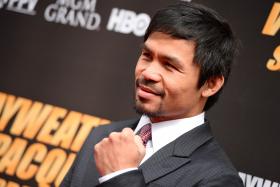 Boxer Manny Pacquiao poses on the red carpet before a joint press conference with Floyd Mayweather Jr on March 11, 2015 at the Nokia Theatre at LA Live in Los Angeles, California. Mayweather and Pacquiao are scheduled to fight May 2, 2015 in Las Vegas.
