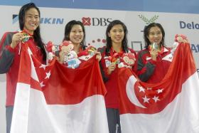 Quah Ting Wen, Hoong En Qi, Amanda Lim and Marina Chan celebrate after winning gold in the women&#039;s 4x100m freestyle relay event of the 28th SEA Games.