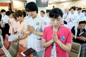 Hospital workers praying during a mass for Mers patients at a hospital in Seoul on Friday (June 12)