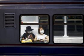 Women wearing masks to prevent contracting MERS ride subway train in Seoul.