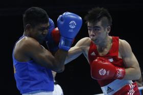 BRONZE MEDALLIST: Timor Leste’s Henrique Martins Borges Pereira (left) being beaten by Singapore’s Tay Jia Wei in the men’s welterweight semi-finals. 