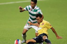 EAGLE ON TOP: Geylang International&#039;s hat-trick hero Hafiz Nor (in white and green) holding off SRC&#039;s Khyruddin Khalid.