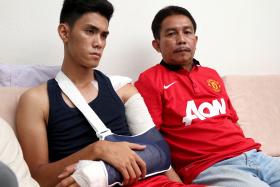 GRIEVING: Azreen Sairudin and his father Sairudin Sani, who is wearing the Manchester United jersey Aqil gave him for his birthday in December.