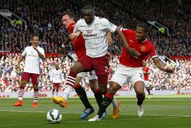 BATTERING RAM: Christian Benteke holding off the challenges of Manchester United&#039;s Phil Jones (left) and Antonio Valencia (right) in an EPL game in April.Benteke scored but Villa lost 3-1.