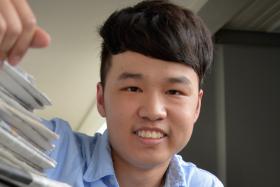 IN AID: Poly student Ong Jie Jun collects newspapers to help the needy.