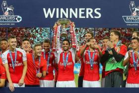 RED TIDE: Arsenal's Mikel Arteta lifting the Barclays Asia Trophy after their demolition of Everton in the final.
