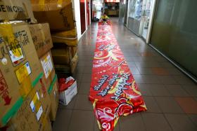 BOOM TIMES: A Singapore-themed banner being rolled up at R A International Marketing.