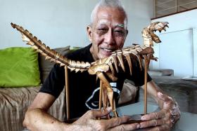 FOR HIS SON: Mr Chan with the dinosaur skeleton origami he folded with three others as a gift to his son more than five years ago.