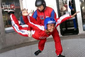 TOUGH: First Warrant Officer Ivan Low correcting TNP reporter Hisyam Nasser&#039;s free fall posture in the iFly wind tunnel.