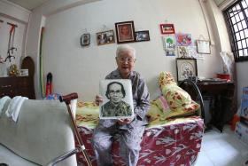 A LIFETIME  OF MEMORIES: Madam Lim Beak holding an old photo of herself.
