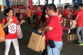 FREE: A promoter distributing free TNP print copies and digital access cards in the TNP bags at the Marina Bay Floating Platform on Aug 9.