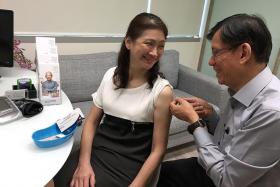 PREVENTIVE MEASURE: Dr Leong Hoe Nam vaccinating patient Ms Teo Guat Kim against pneumonia.