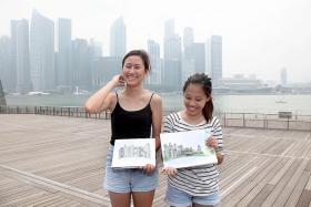 ARTISTIC VIEW: Miss Jolene Quek (left) and Miss Clara Soh with their sketches of the Singapore skyline.