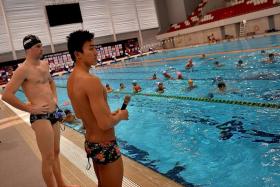 WATCHFUL: America&#039;s Kevin Cordes (right) and Singapore&#039;s Quah Zheng Wen (with microphone) supervising swimmers at a clinic at the OCBC Aquatic Centre yesterday.