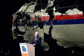 FINDING ANSWERS: Dutch Safety Board Chairman Tjibbe Joustra speaking in front of the reconstructed wreckage of the Malaysia Airlines Boeing 777.
