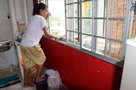 SCARED: Madam Zahirah Mohamed Sultan showing how she climbed out her kitchen window after her boyfriend broke into her flat. 
