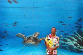 HELP PEOPLE: Mr Hilton Alves, a Brazilian artist, in action at one of the three oceanthemed murals at Sentosa. The one he painted on a wall at Beach Station (above) will be Asia’s largest ocean mural.