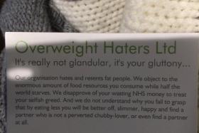 Passengers traveling on the London Underground have been handed abusive cards telling them that they are fat.