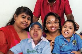 FAMILY ROCK: Miss Pushpika (above left in red), a Sri Lankan maid, with Madam Selva and her husband Mr Balan with their two children Ravindran (left) and Arvind, who died from a musculoskeletal disorder.