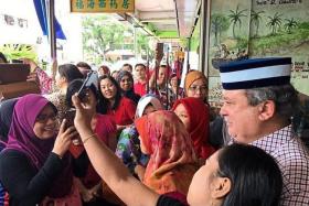 ON THE GROUND: Sultan Ibrahim Sultan Iskandar posing for a wefie with members of the public.