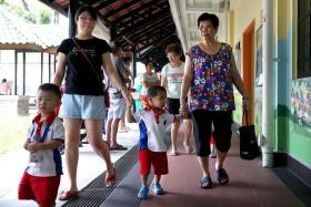 ANXIOUS: Madam Angela Lim (in black top) taking her son to school.