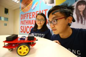 MIND POWER: Engineering Science students Max Pang Ek Wee and Kimberlyn Loh Cheng Lin with their mind-controlled robot. 