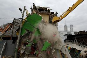 DEMOLISHED: (Above) Bulldozers knock down buildings in Kalijodo red-light district of Jakarta, Indonesia, on Feb 29 as part of a nationwide effort to eradicate prostitution. 