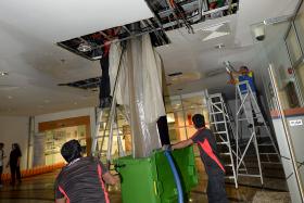 CLEANING UP: A kitchen waste pipe in Shaw Foundation Alumni House burst, causing waste water to leak from the ceiling to the floor of the first storey. TNP PHOTOS: CHOO CHWEE HUA