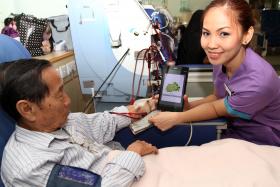TRANSLATION HELP: NKF’s healthcare assistant Junna Rae Estampador can now communicate better with her patient, Mr Lai Kim Leong. 