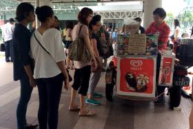 HIS TREAT: Customers queueing for Mr Jimmy Teng’s free ice cream outside Lavender MRT station.